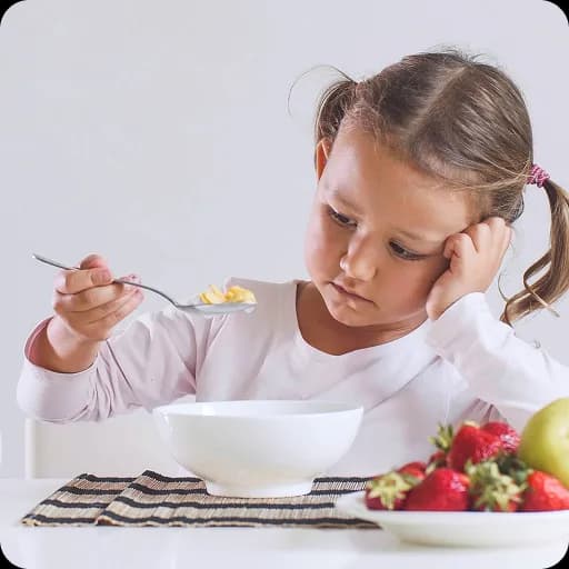 Girl eating a bowl of fruit and cereal