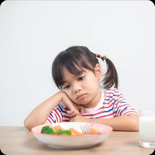 Girl looking unhappy at a plate of food