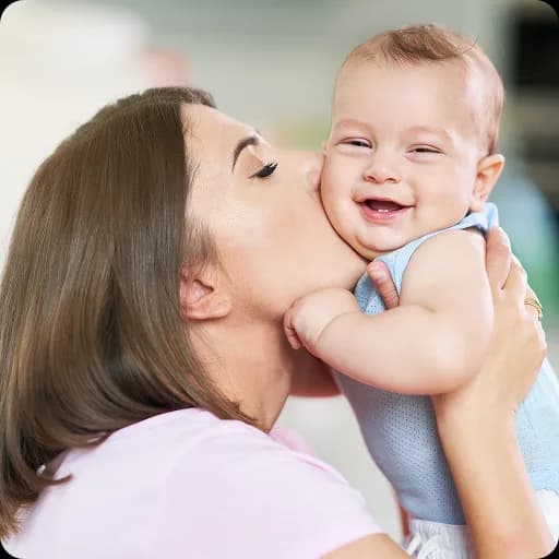 Mother kissing a smiling baby