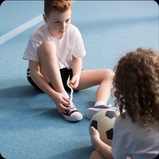 Children sitting on a sports hall floor