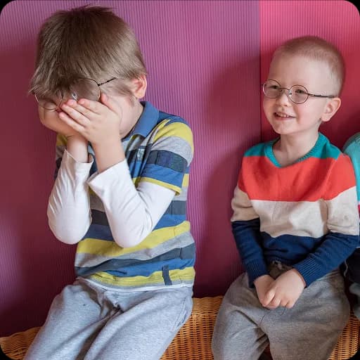 Two boys sitting together looking upset