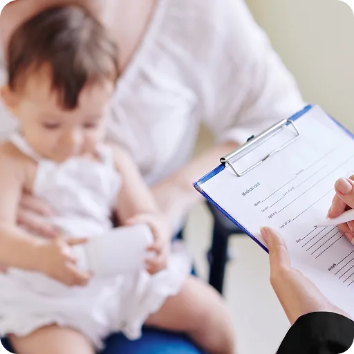 Consultant completing a medical record beside a baby and parent