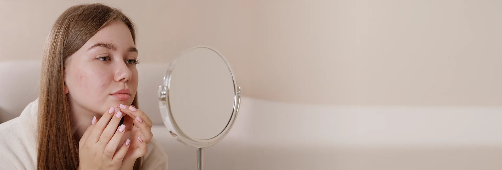 Teenage girl looking at her skin in a mirror