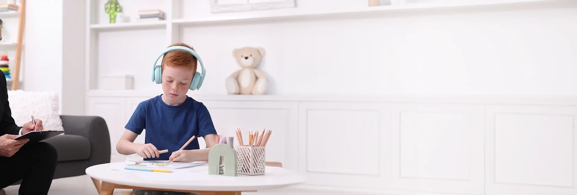 Boy wearing headphones at a table in a clinic