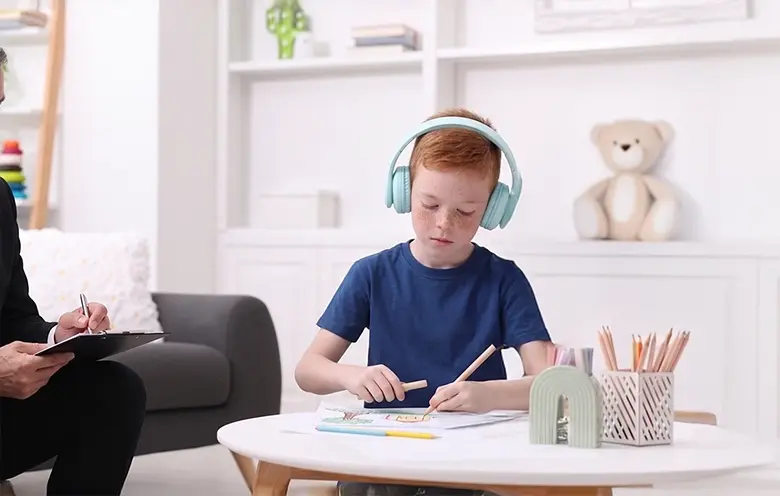 Boy wearing headphones at a table in a clinic