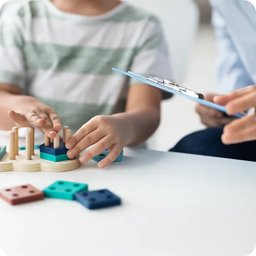 Child playing with toys at a table during an assessment