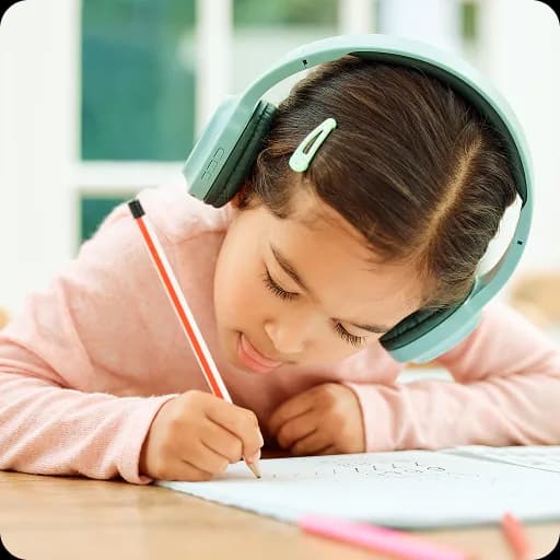 Girl with headphones drawing at a table