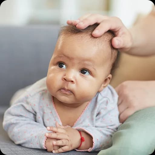Baby lying on its back with a hand on its head
