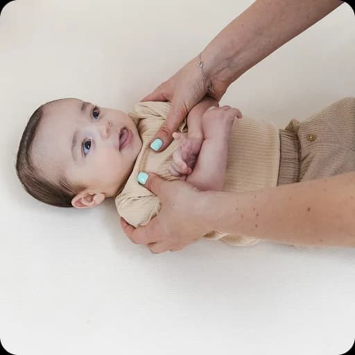 Hands gently examining a baby