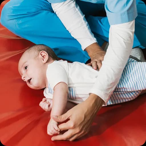 Physiotherapist working with a baby on a mat