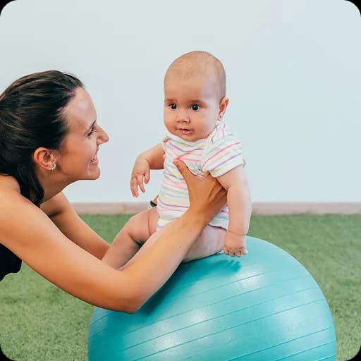 Therapist supporting a baby on an exercise ball