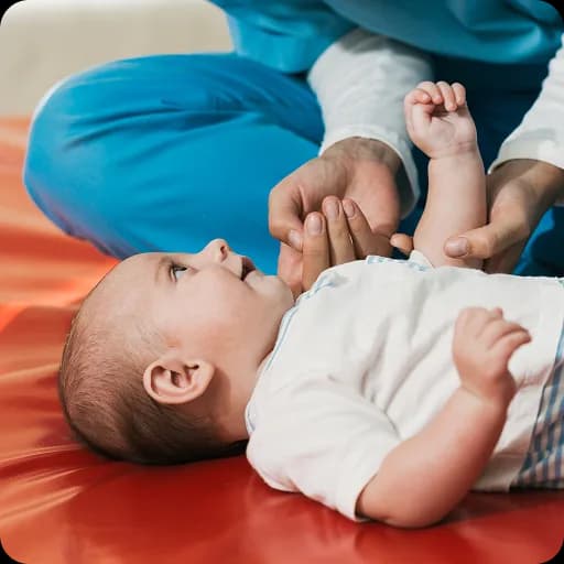 Therapist working with a baby on a mat