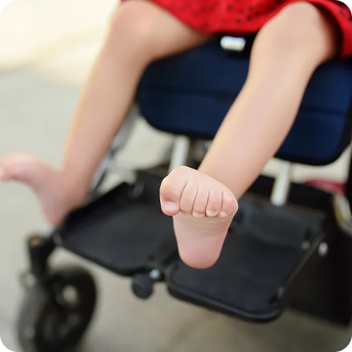 Child's feet on a wheelchair footrest