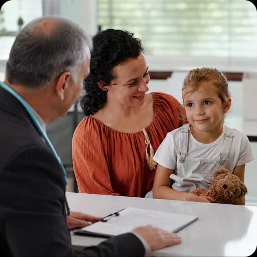 Paediatrician with a mother and child at a desk