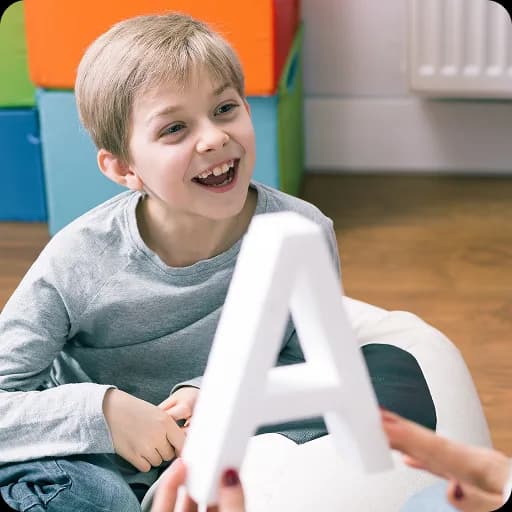 Smiling boy holding a letter A shape