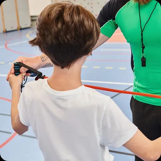 Therapist working with a boy in a gym