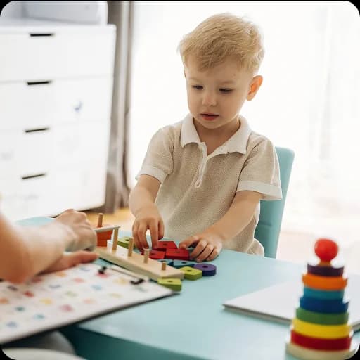 Toddler playing with stacking rings at a table