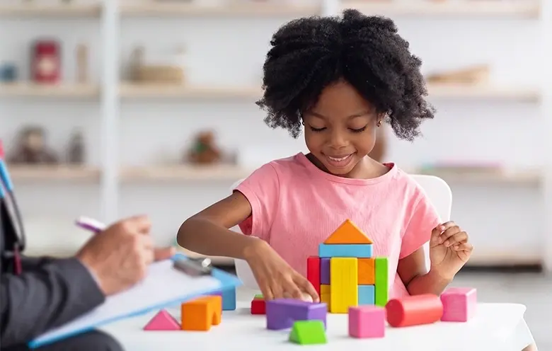 Young girl playing with building blocks during an assessment