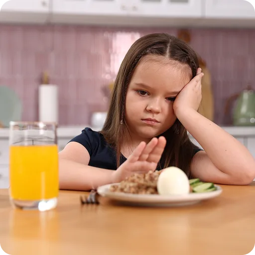 Girl resting her head beside a plate of food