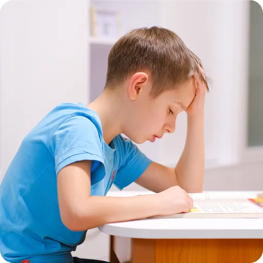 Boy resting his head on a desk