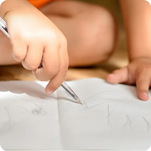 Child drawing on paper at a table