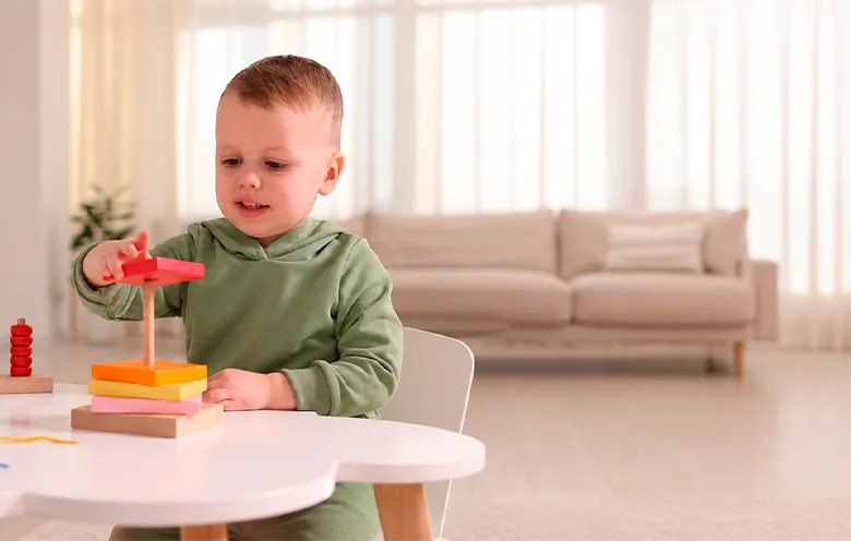 Toddler playing with a stacking toy at home