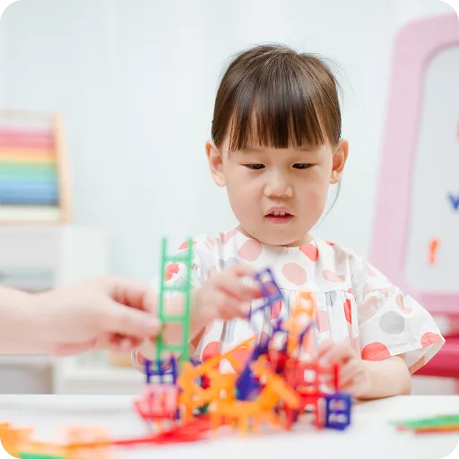 Young girl playing with toys at a table