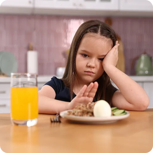 Girl looking unhappy at a plate of food