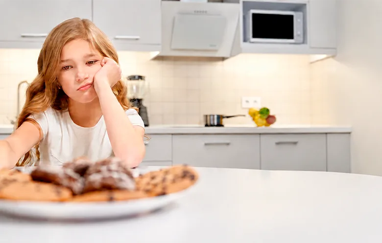 Girl looking unhappy at a plate of food