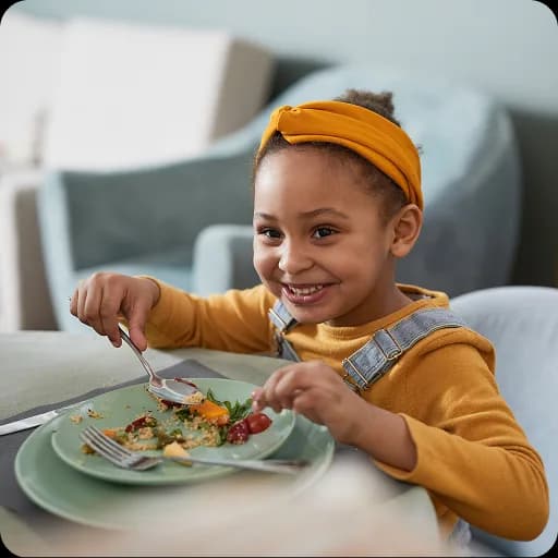 Smiling child eating a healthy meal