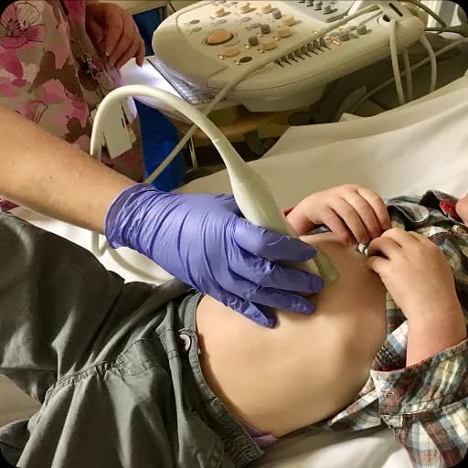 Gloved hand performing an ultrasound on a child
