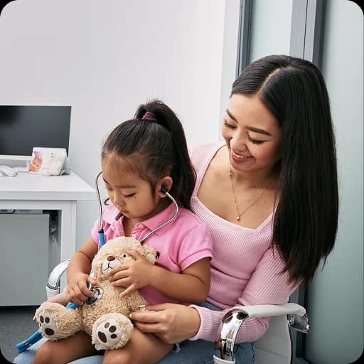 Mother holding a young girl at a consultation