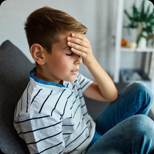 Boy holding his head on a sofa