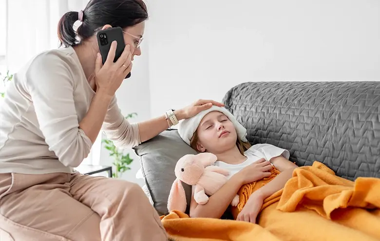 Mother caring for an unwell child on a sofa