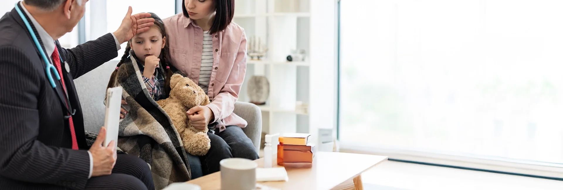 Paediatrician examining a girl with her mother