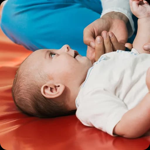 Doctor examining a baby on a mat
