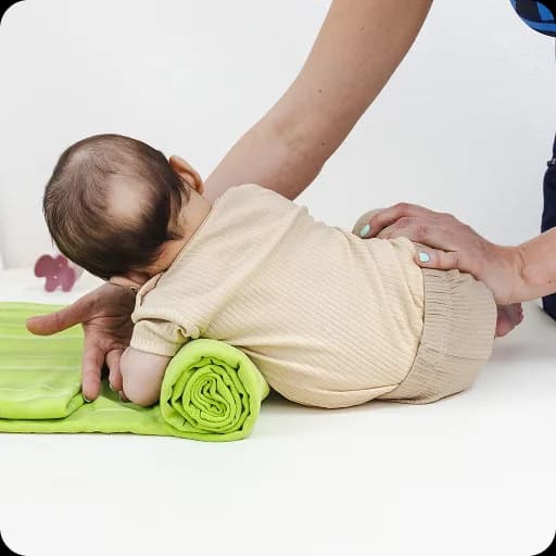 Physiotherapist working with a baby on a mat