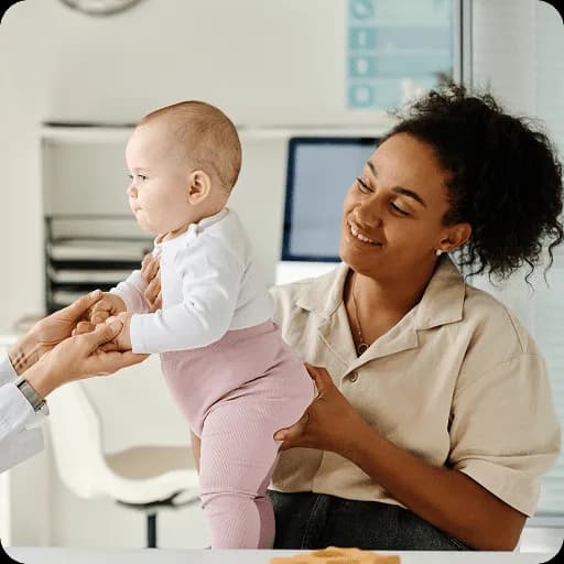 Nurse weighing a baby on scales