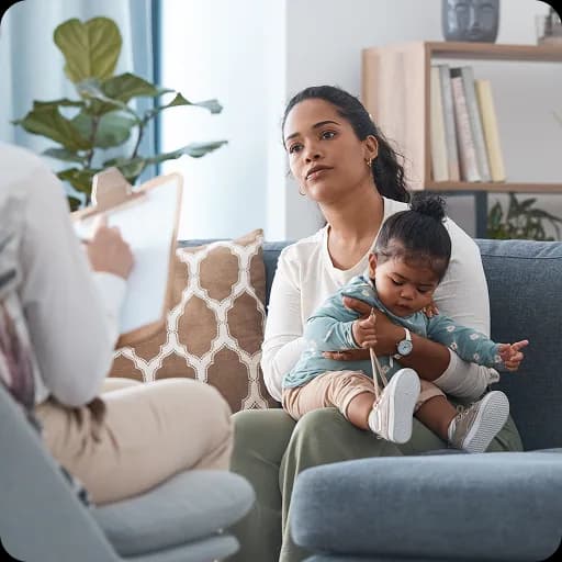 Mother holding a baby on a sofa