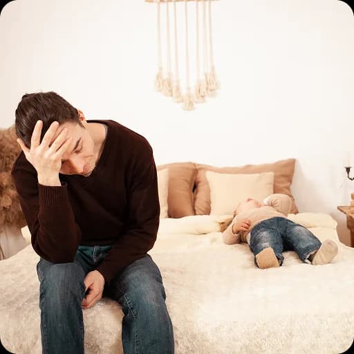 Mother sitting with her head in her hand