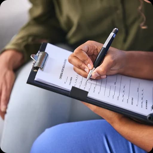 Hand writing notes on a clipboard