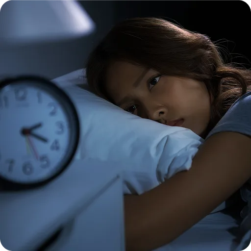 Child asleep beside an alarm clock