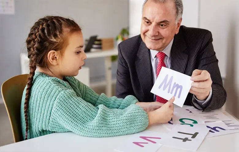 Paediatrician showing a card to a young girl