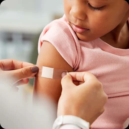 Plaster being applied to a child's arm after a vaccination