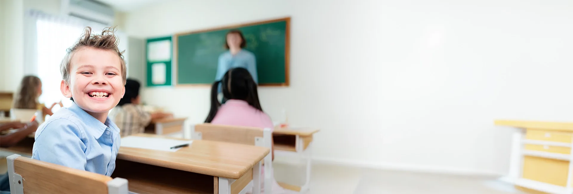 Boy sitting at a desk in a classroom